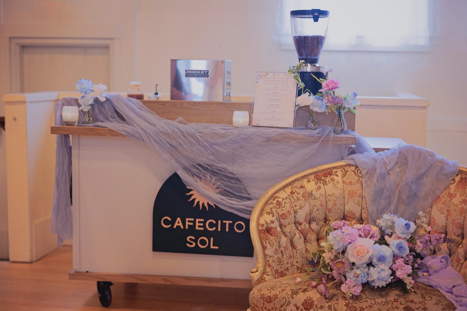 The Cafecito Sol coffee cart styled with florals at a wedding reception
