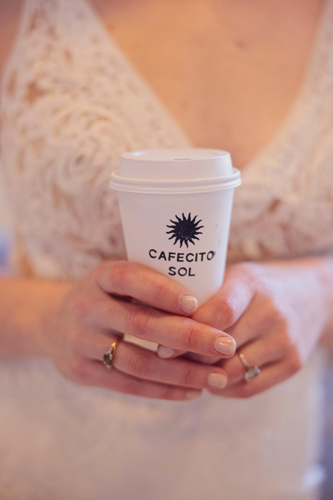 A bride holding a Cafecito Sol coffee cup at her wedding